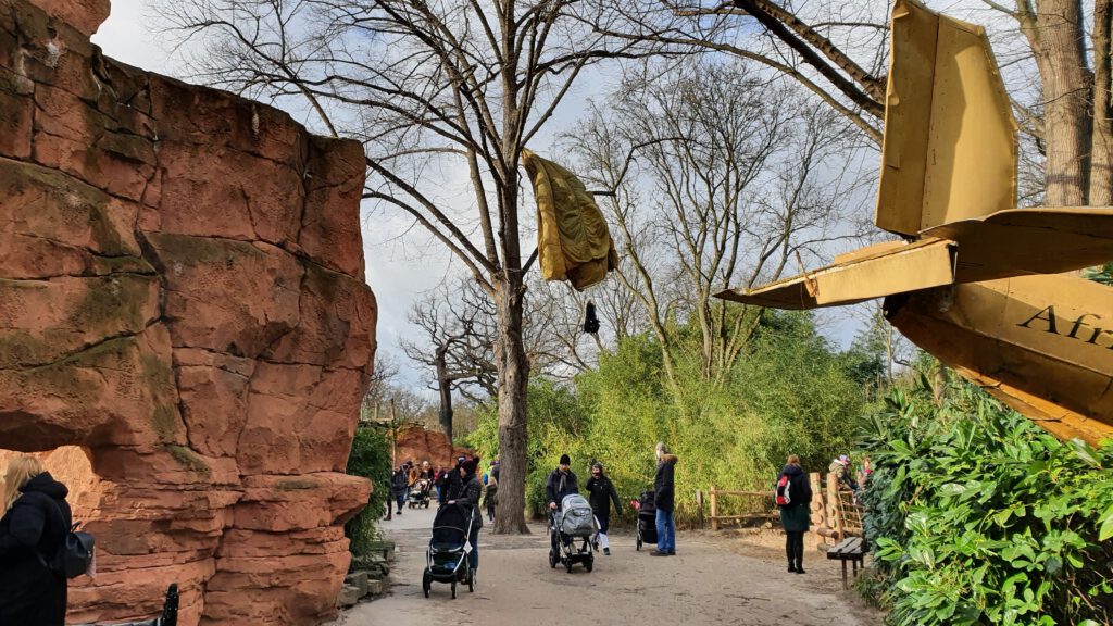 Erlebniszoo Hannover am Löwengehege mit Besuchern und einem Flugzeugwrack